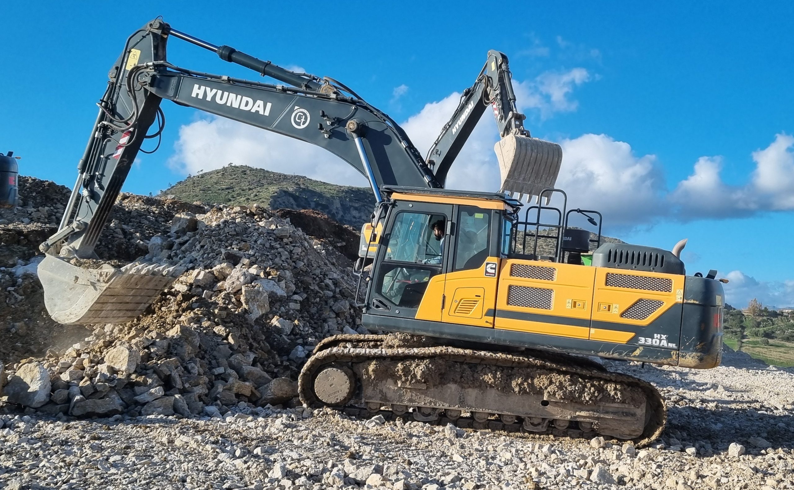 Un escavatore cingolato Hyundai HX330ANL durante le operazioni di movimentazione roccia in cava.
