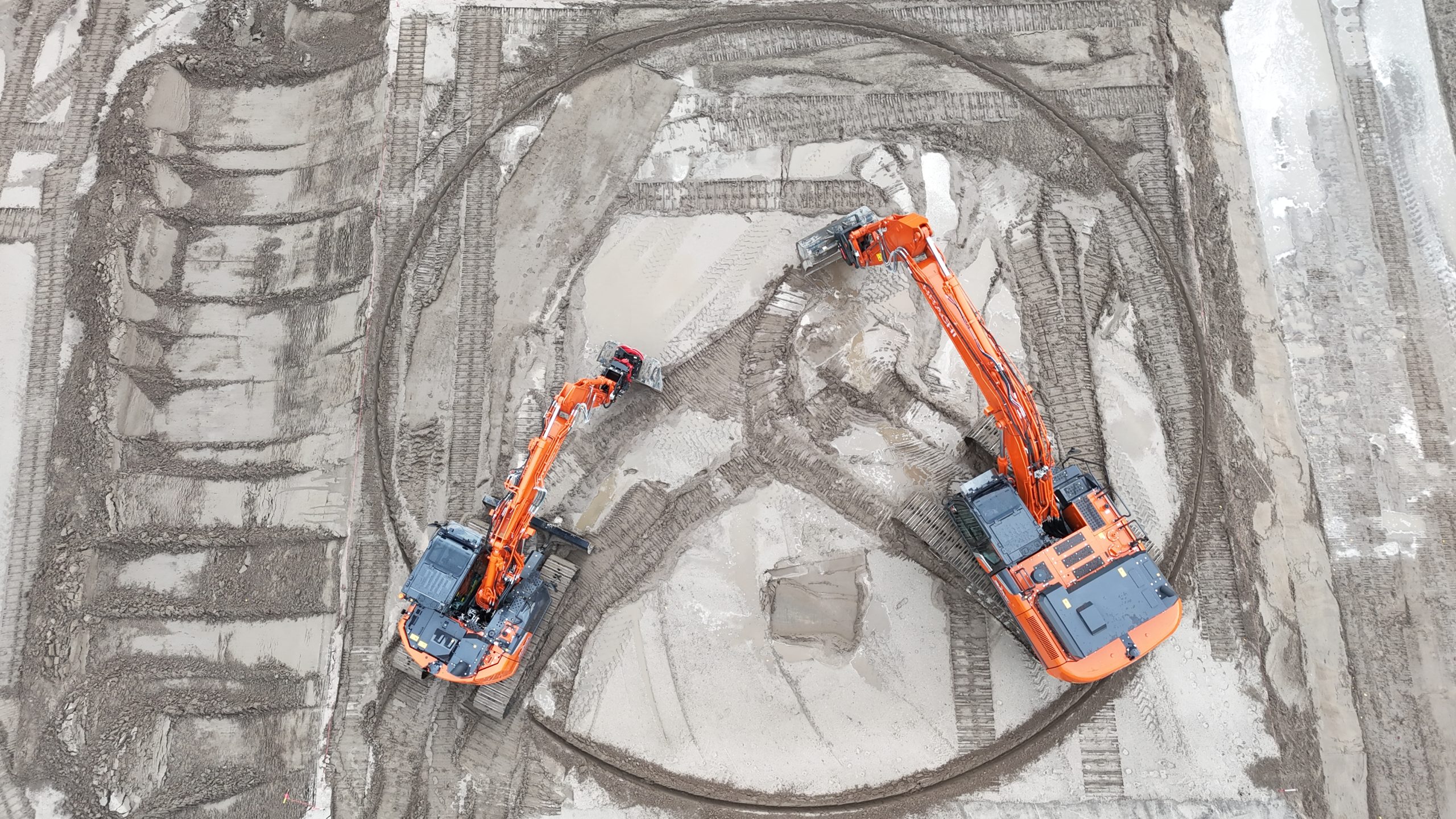 Due escavatori Hitachi si sfidano nei complessi percorsi tracciati sul terreno per la LANDCROS European Operator Challenge.