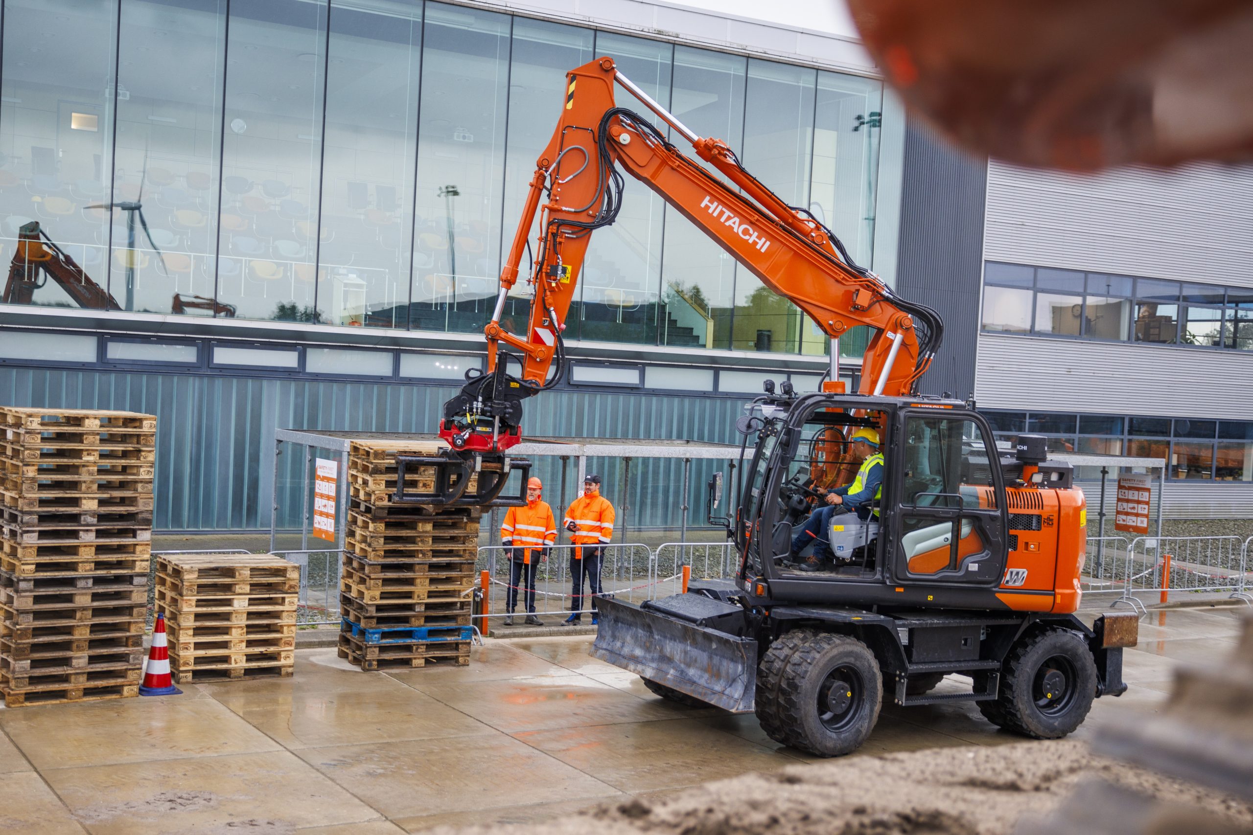 Massima stabilità e destrezza: un escavatore compatto Hitachi alle prese con la movimentazione dei pallet.