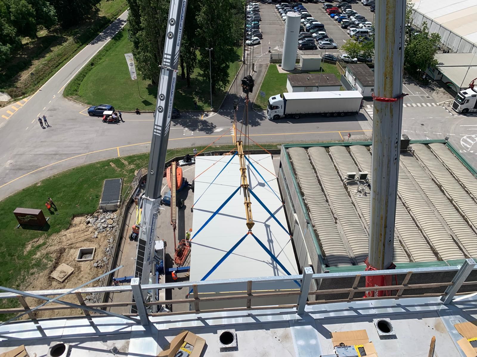 La complessa manovra di posizionamento in quota del colosso in acciaio per lo stabilimento Martino Rossi, assistita dalle piattaforme aeree EUROTECNO.