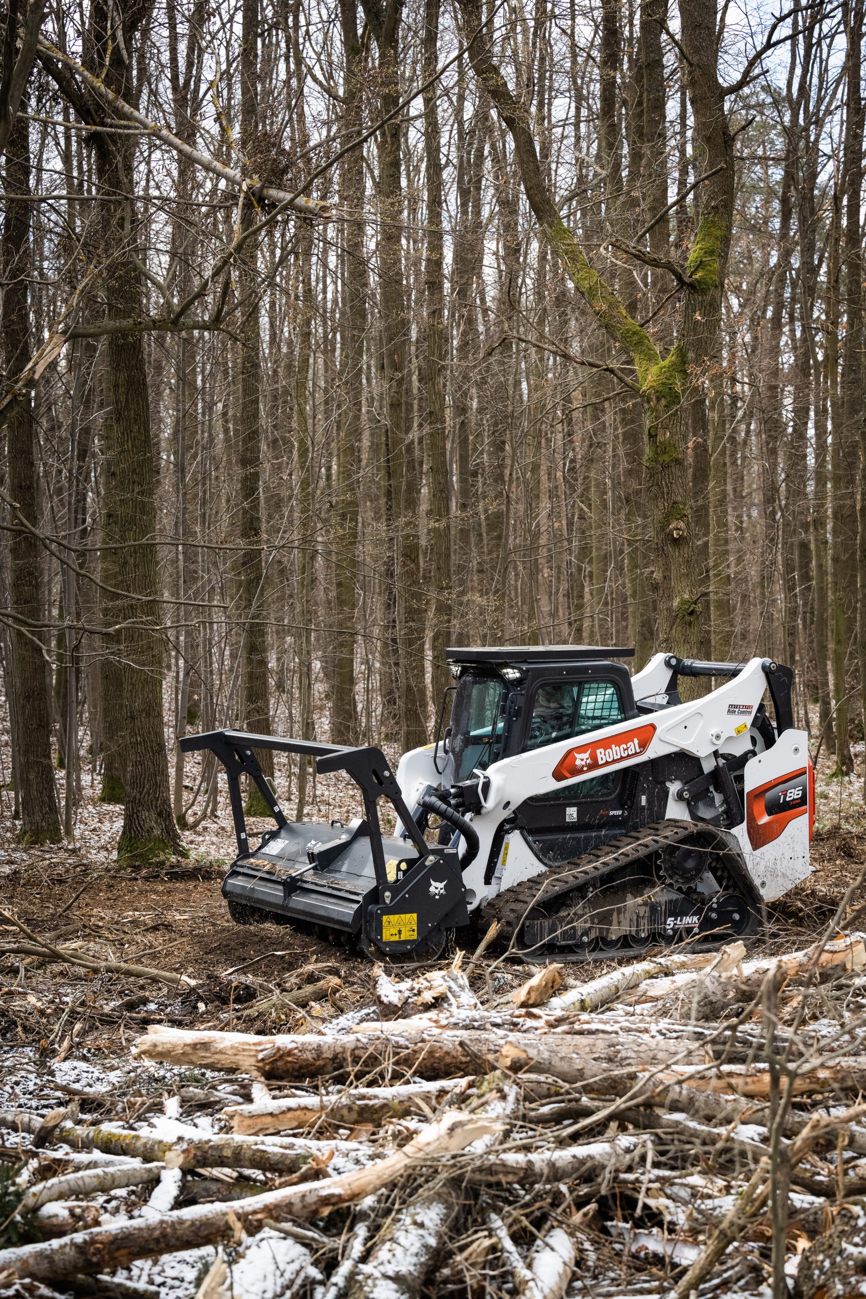 Pala cingolata Bobcat T86 con trinciatutto forestale: potente ed efficace per la riduzione del combustibile vegetale e la prevenzione degli incendi.