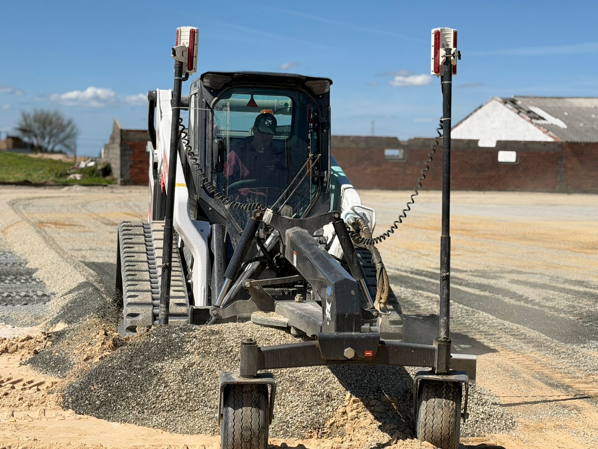 La pala cingolata Bobcat equipaggiata con livellatrice laser durante la stesura e il perfetto livellamento del fondo per un campo equestre.