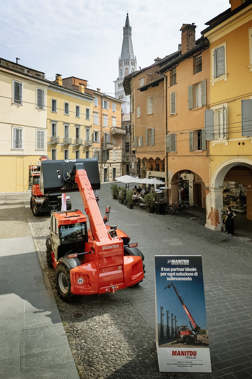 I sollevatori telescopici di Manitou Italia esposti in Corso Canalchiaro a Modena durante il Motor Valley Fest. Sullo sfondo la storica torre della Ghirlandina, simbolo di un territorio straordinario che unisce la tradizione motoristica all'avanguardia tecnologica del brand di Castelfranco Emilia.