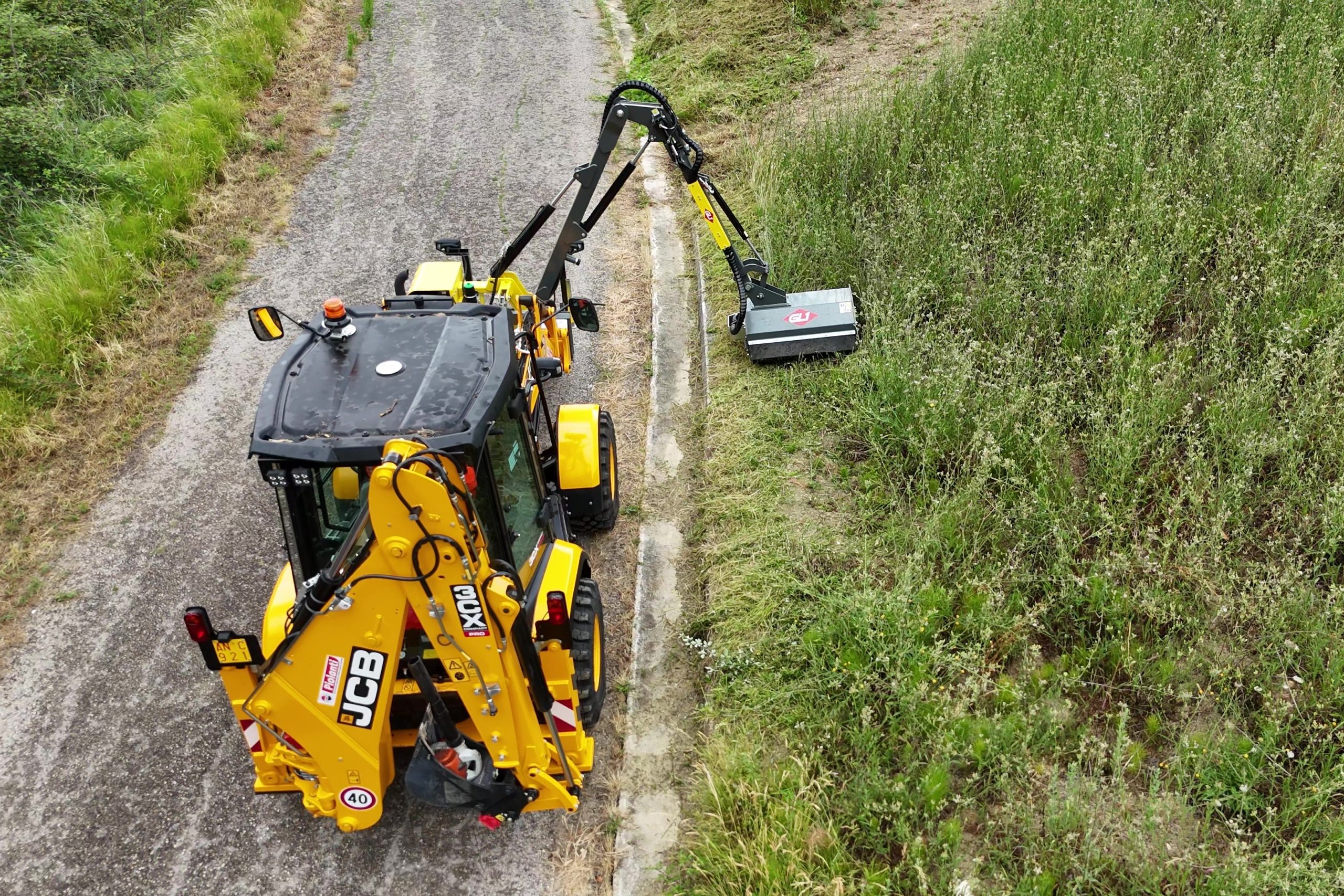 La JCB 3CX Compact Pro è allestita con un braccio falciante della GL1