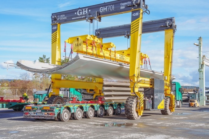Operazioni di carico: la gru a portale mobile posiziona con precisione un semiguscio in calcestruzzo per torri eoliche sul pianale allungabile del semirimorchio MAX Trailer MAX810.