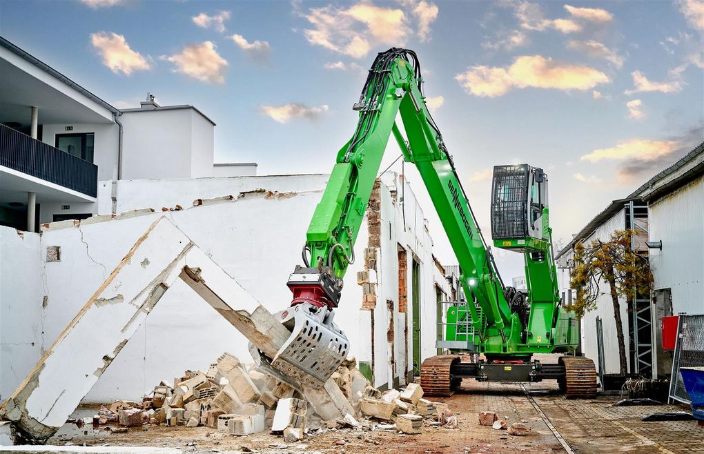 L'escavatore SENNEBOGEN 825 E Demolition al lavoro con pinza selezionatrice in un cantiere urbano a spazi ristretti.