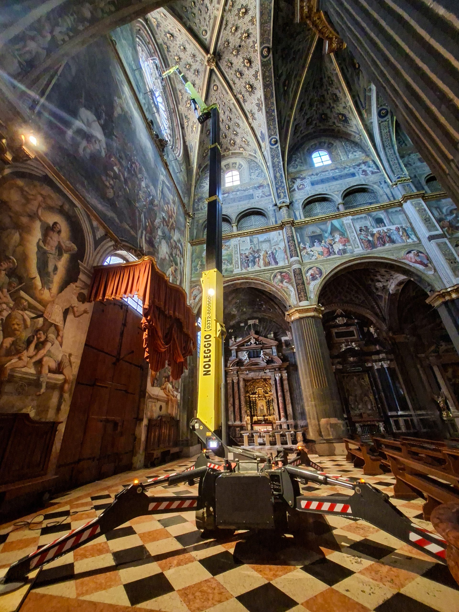 La piattaforma aerea Hinowa Lightlift 33.17 Performance IIIS di Eurotecno in azione all'interno della Cattedrale di Cremona, posizionata con i stabilizzatori aperti per l'intervento in quota sul rosone.