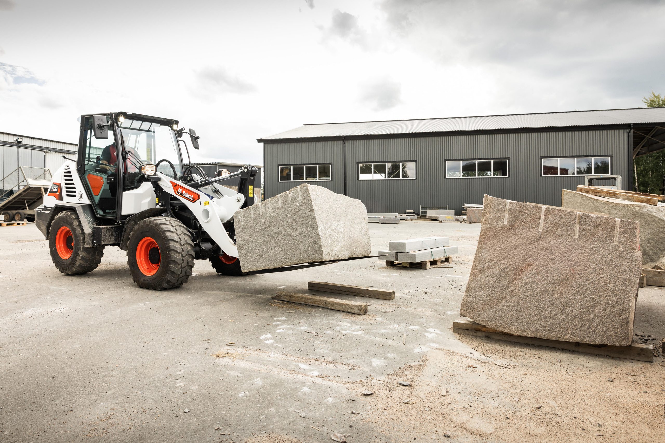 La pala compatta Bobcat L85 impegnata nella movimentazione di materiali pesanti in cantiere, grazie a prestazioni idrauliche e forze di strappo superiori.