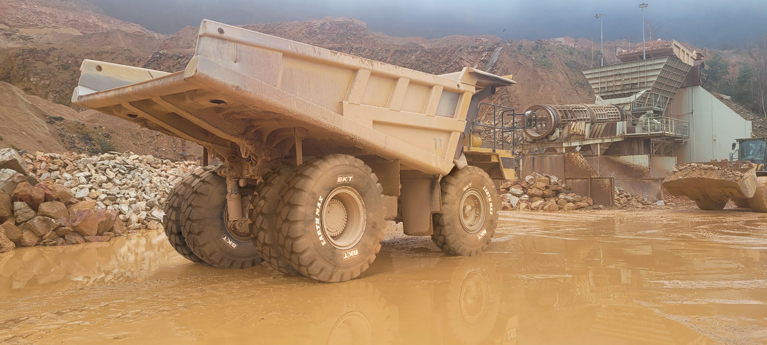 Un dumper rigido in azione su superfici ostili, equipaggiato con lo pneumatico EARTHMAX SR 47 TP di BKT, scelto per garantire massima trazione e resistenza in cava.