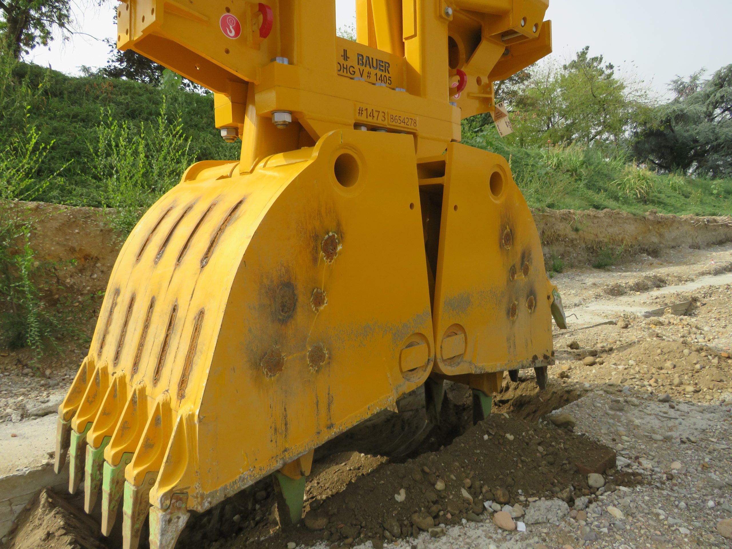Primo piano della benna idraulica BAUER DHG-V in azione nel cantiere della stazione Parri di Milano.