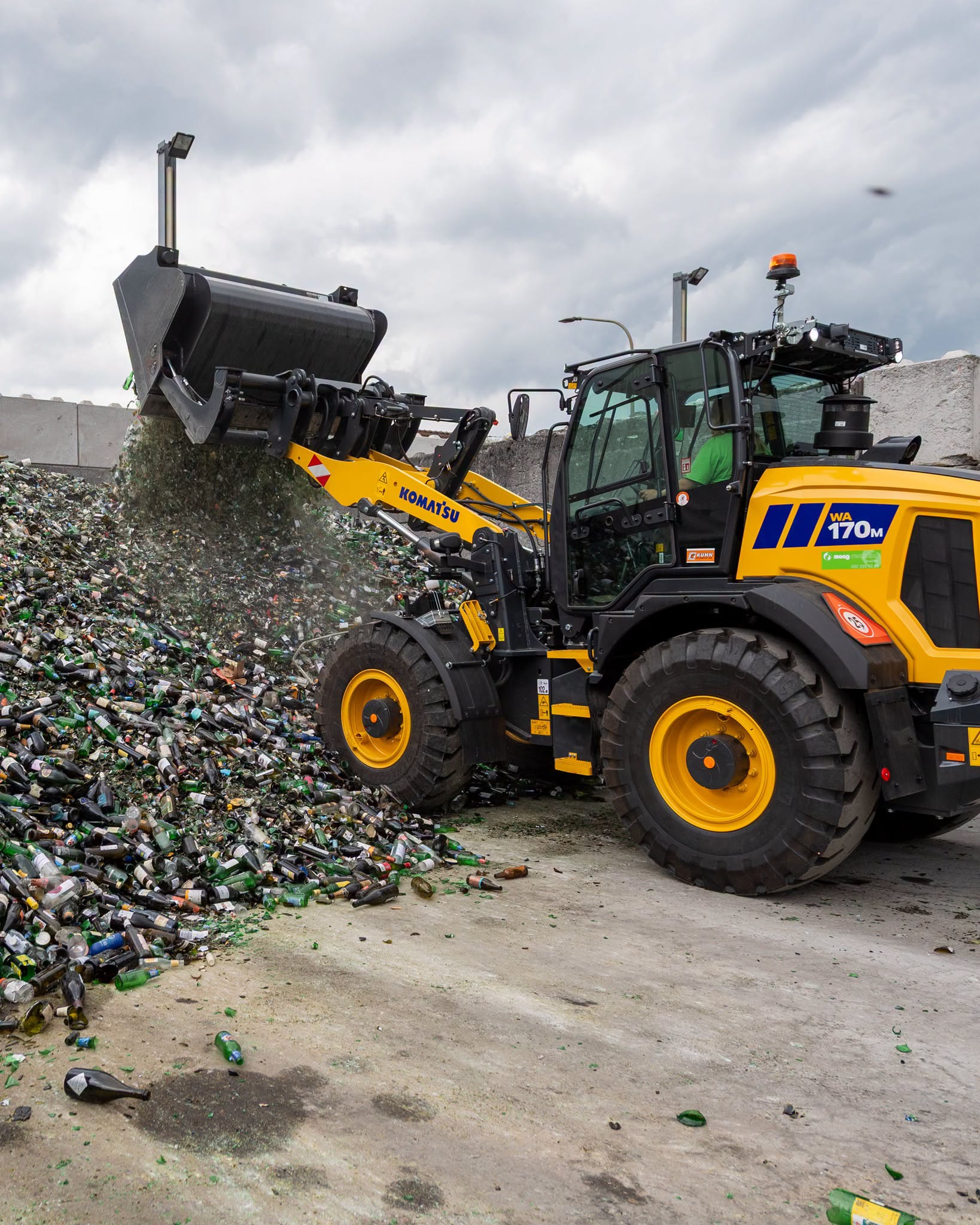 La pala gommata compatta Komatsu WA170M-11 impiegata da Maag Recycling per il riciclaggio e la movimentazione del vetro nel sito industriale.   
