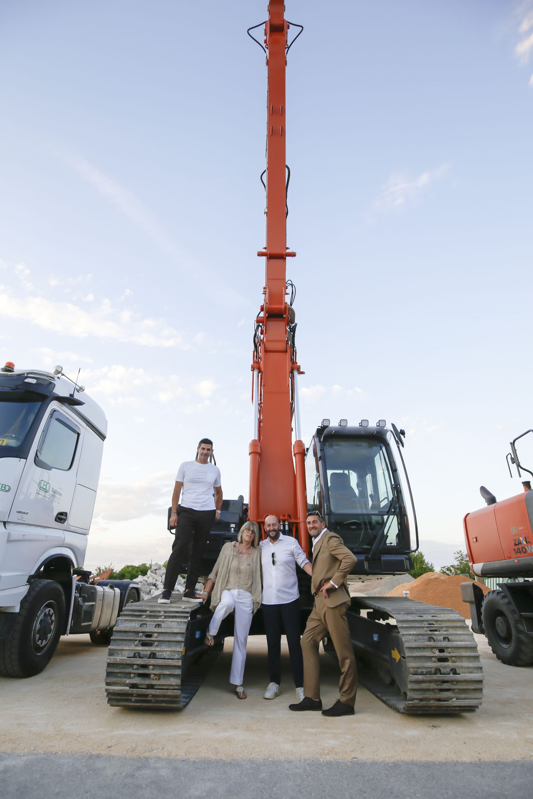 Marco e Roberta Battiston, Marco Salomoni e Stefano Battiston davanti al nuovo escavatore Hitachi ZX250-7 in configurazione SLF.